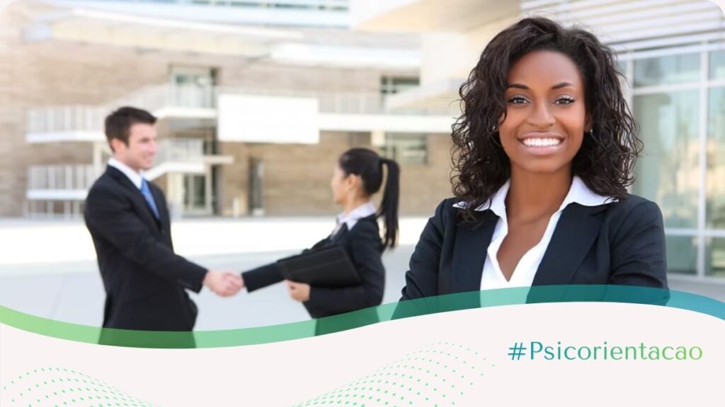 Retrato em primeiro plano de uma executiva negra vestida com traje formal de negócios, transmitindo confiança e prontidão. Ao fundo, em um escritório moderno e levemente desfocado, observa-se um rapaz branco trabalhando e cumprimentando cordialmente uma colega. A imagem representa o ambiente corporativo contemporâneo e ilustra as dicas para entrevistas de emprego, enfatizando a importância da apresentação pessoal, da autoridade profissional e da integração em uma cultura de trabalho colaborativa