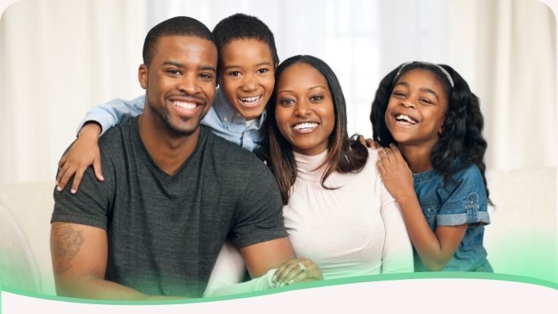 Família negra sorrindo unida, expressando felicidade e conexão saudável, representando o ideal de equilíbrio entre afeto e limites na criação dos filhos