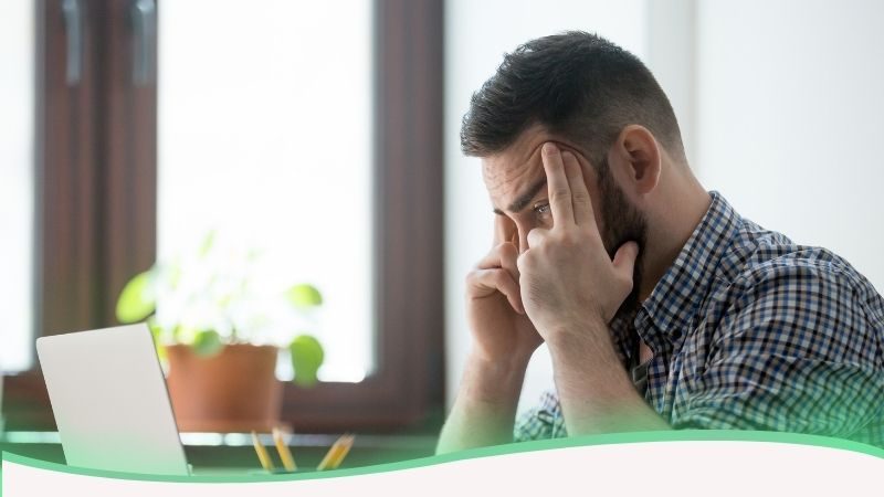 Homem jovem visto de perfil, com as mãos nas têmporas e olhos meios fechados, ilustrando a sobrecarga mental e que qualquer pessoa pode desenvolver transtornos de ansiedade